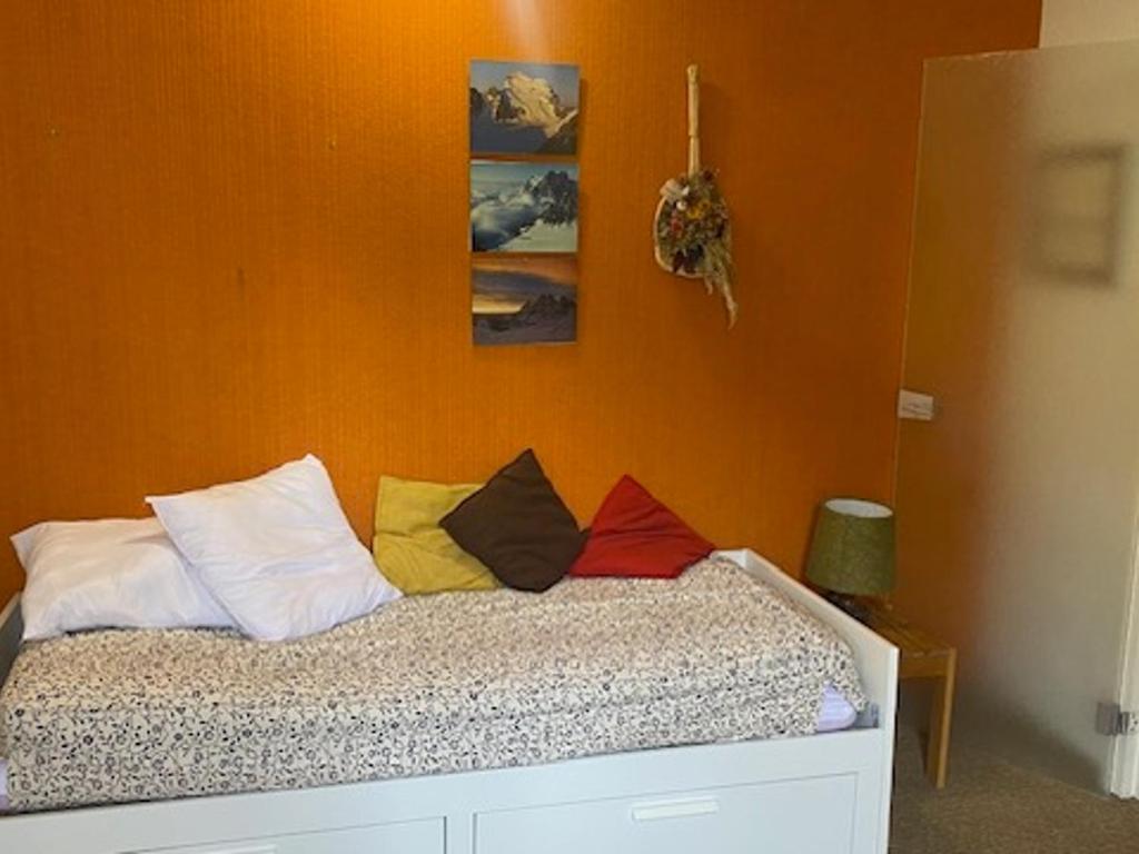 un letto con cuscini colorati sopra di Studio Montgenèvre, 1 pièce, 2 personnes - FR-1-445-154 a Monginevro