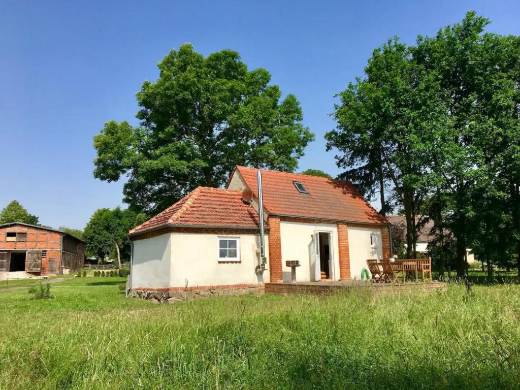 a small white house with a red roof in a field at Backhaus 