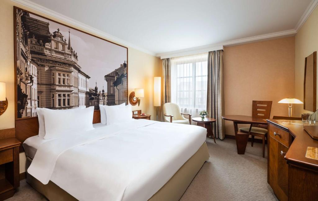 プラハにあるLindner Hotel Prague Castle, part of JdV by Hyattのホテルルーム内の大きな白いベッド