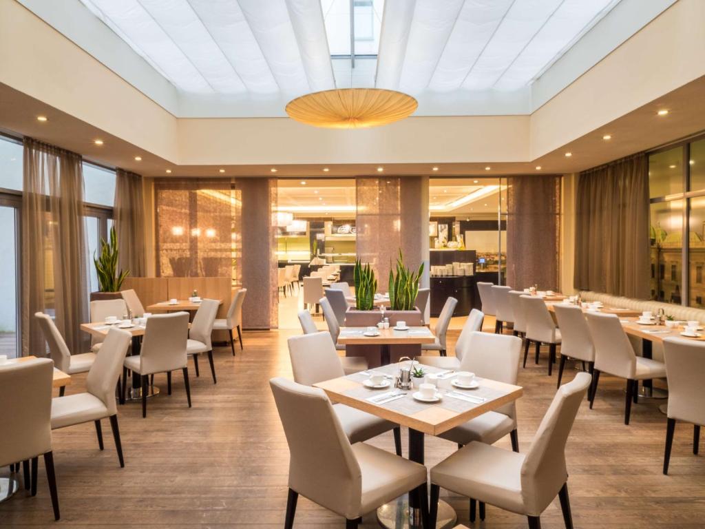 a dining room with tables and chairs at Lindner Hotel Vienna Am Belvedere, part of JdV by Hyatt in Vienna