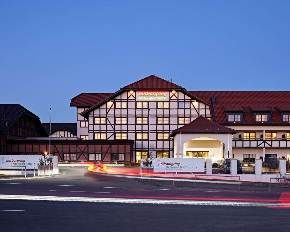 een groot gebouw met een weg ervoor bij Lindner Hotel Nurburgring Motorsport, part of JdV by Hyatt in Nürburg