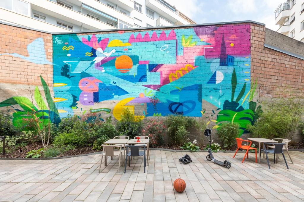 a mural on the side of a building with tables and chairs at ibis budget Strasbourg Centre Republique in Strasbourg