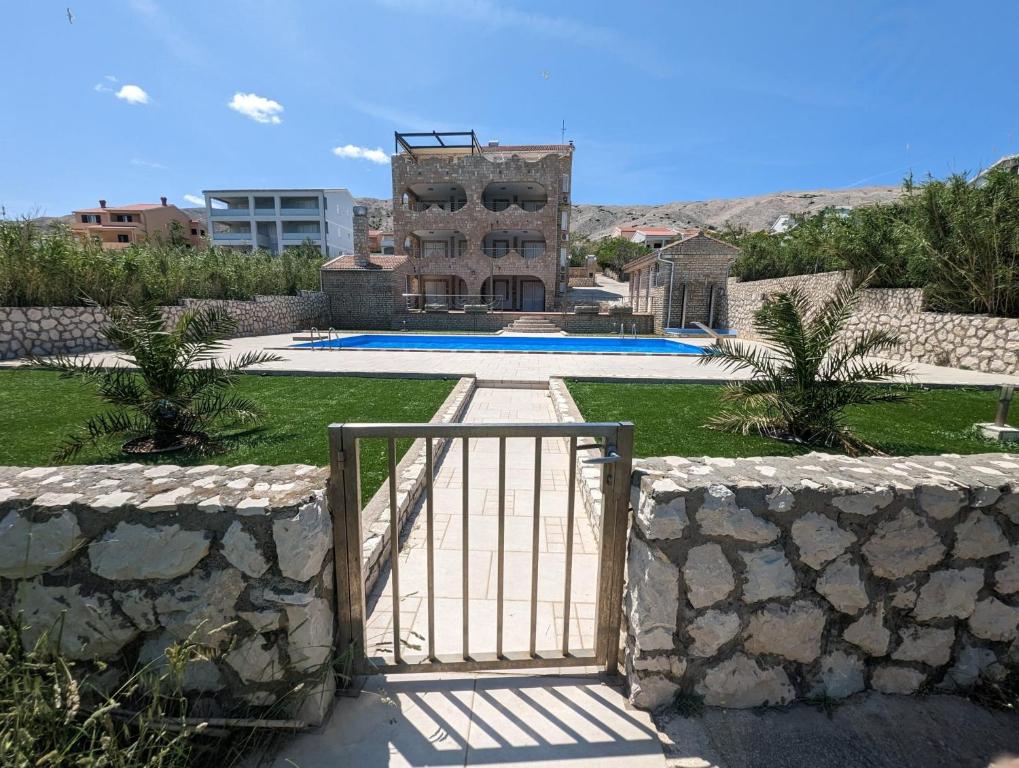 un cancello di fronte a una casa con piscina di Pool apartment Adriana a Pag