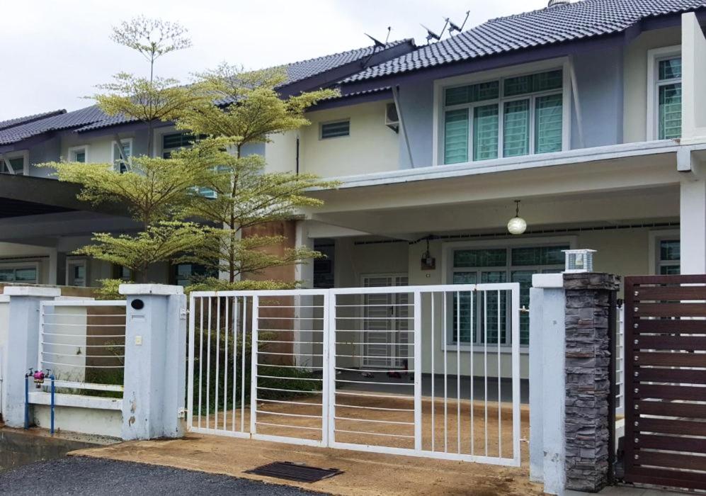 een huis met een witte poort ervoor bij Anugerah Homestay Islam Ayer Keroh, 4 bilik tidur & 4 bilik air in Melaka