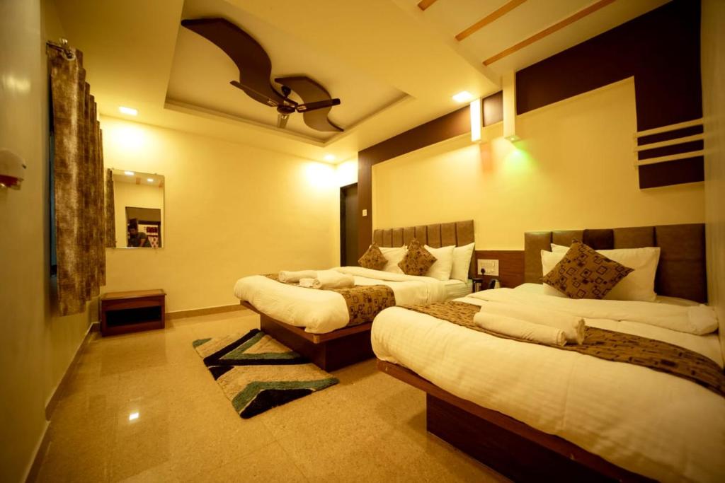 a hotel room with two beds in a room at Misty Mount Villa in Mahabaleshwar