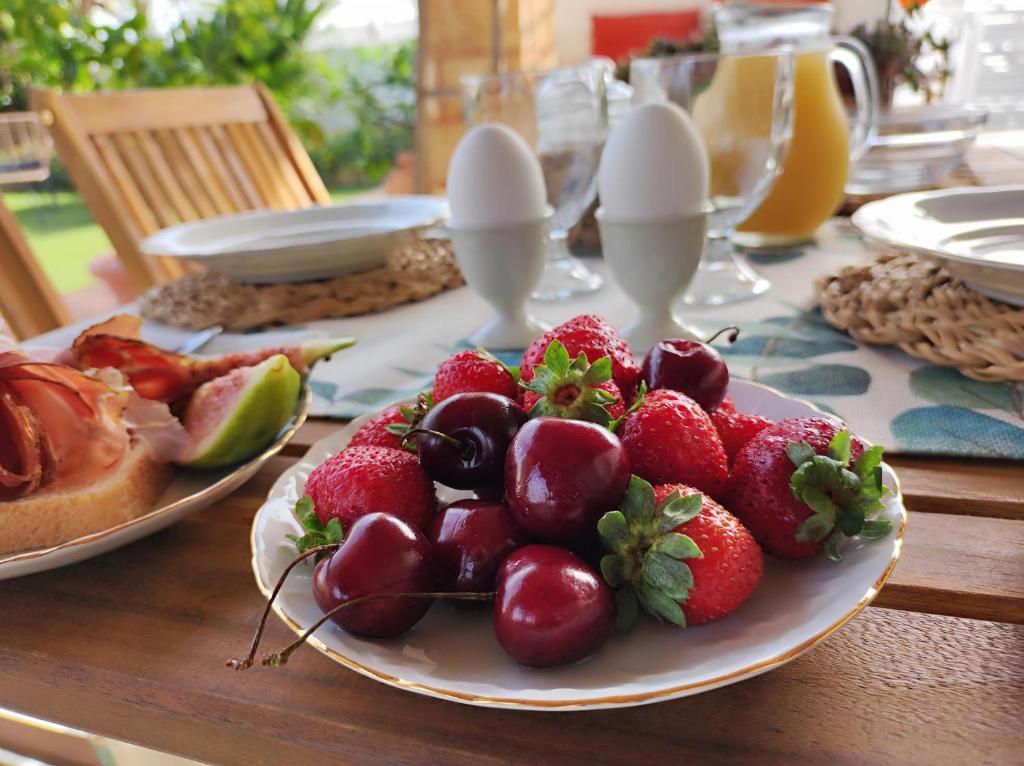 una mesa con fresas y otras frutas en una bandeja en Li Brilli, en Felline