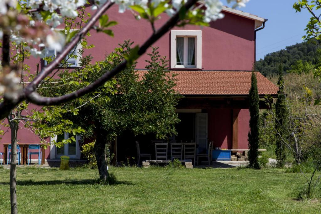 een rood huis met een boom ervoor bij Agriturismo Campoletizia in Miglianico