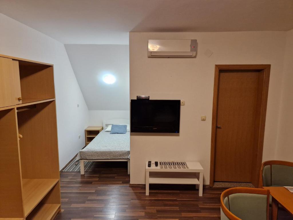 a room with a bed and a flat screen tv at Guest house Wolf II in Plitvička Jezera