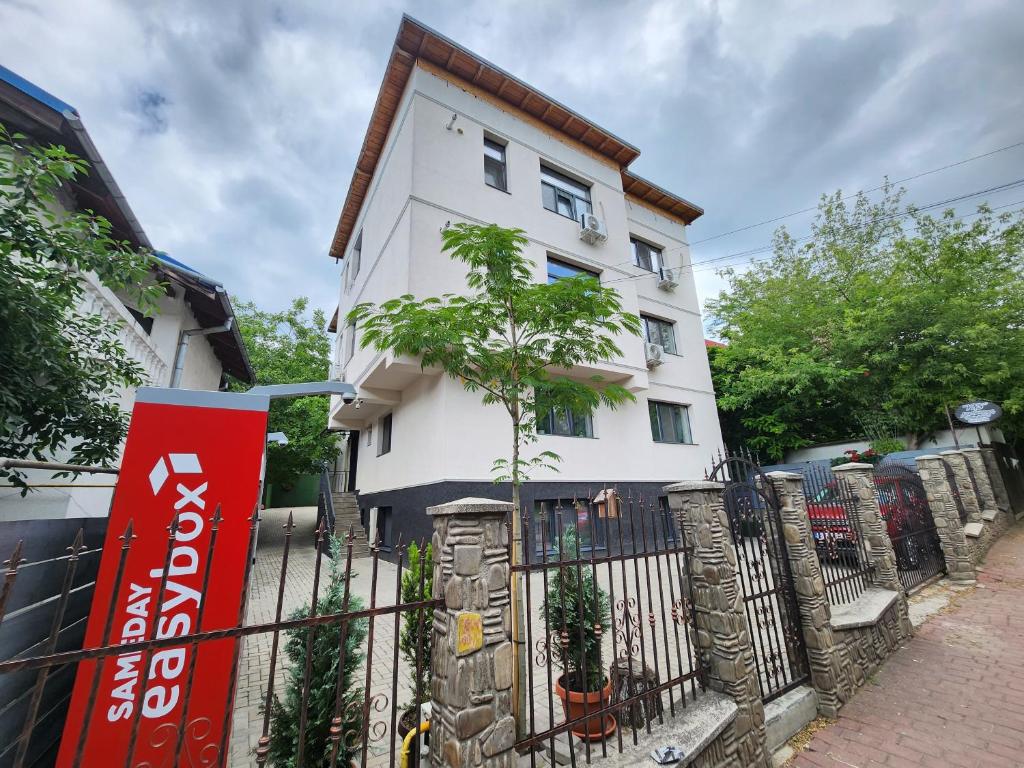 una casa bianca con una recinzione di fronte di Luxe Hideaway Apartments a Iaşi