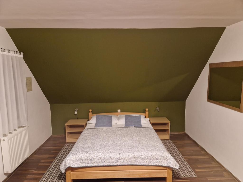a bedroom with a bed and a green wall at Guest house Wolf II in Plitvička Jezera
