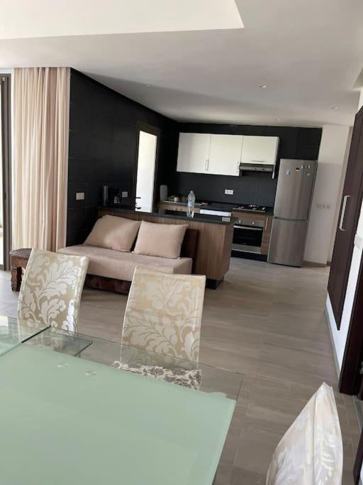 uma sala de estar com um sofá e uma cozinha em Appartement De Luxe à Taghazout em Agadir