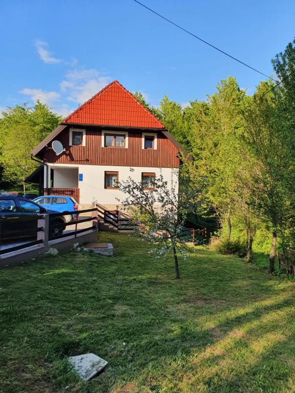 Casa blanca con techo rojo y patio en Guest house Wolf II en Plitvička Jezera