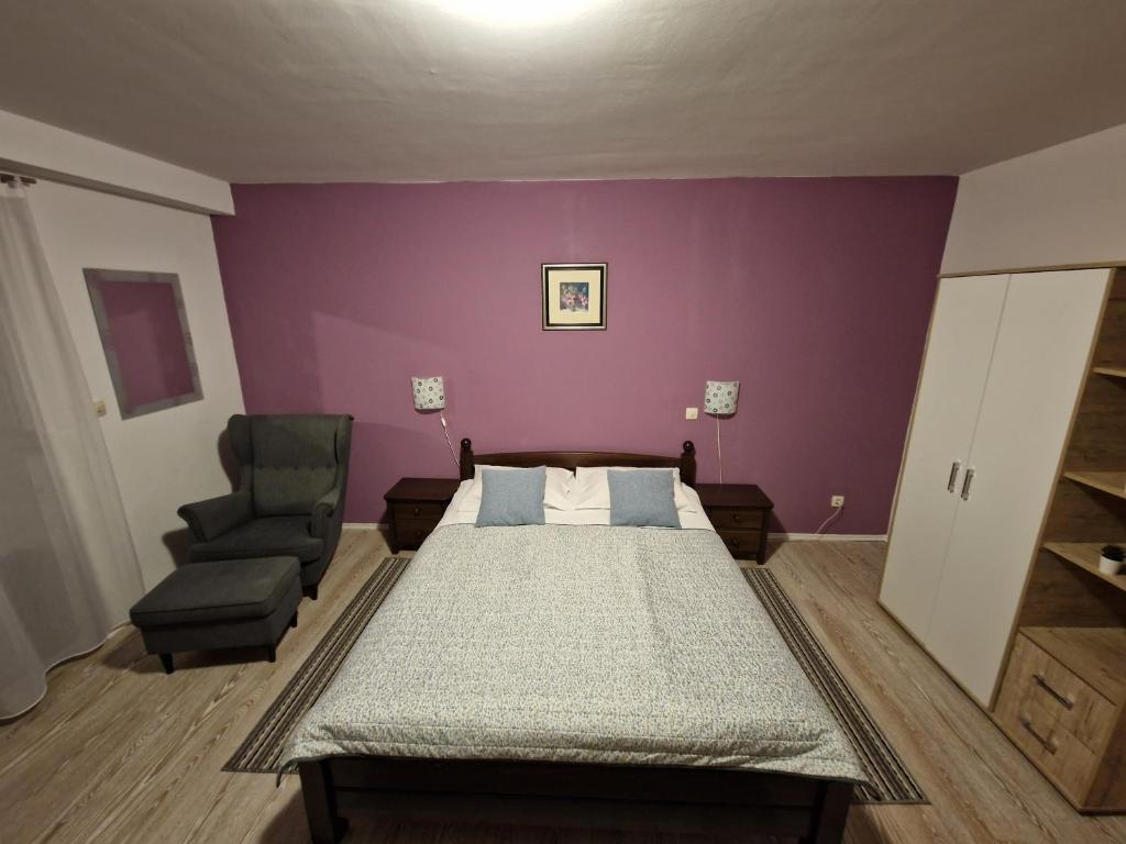 a bedroom with a bed and a chair at Guest house Wolf II in Plitvička Jezera