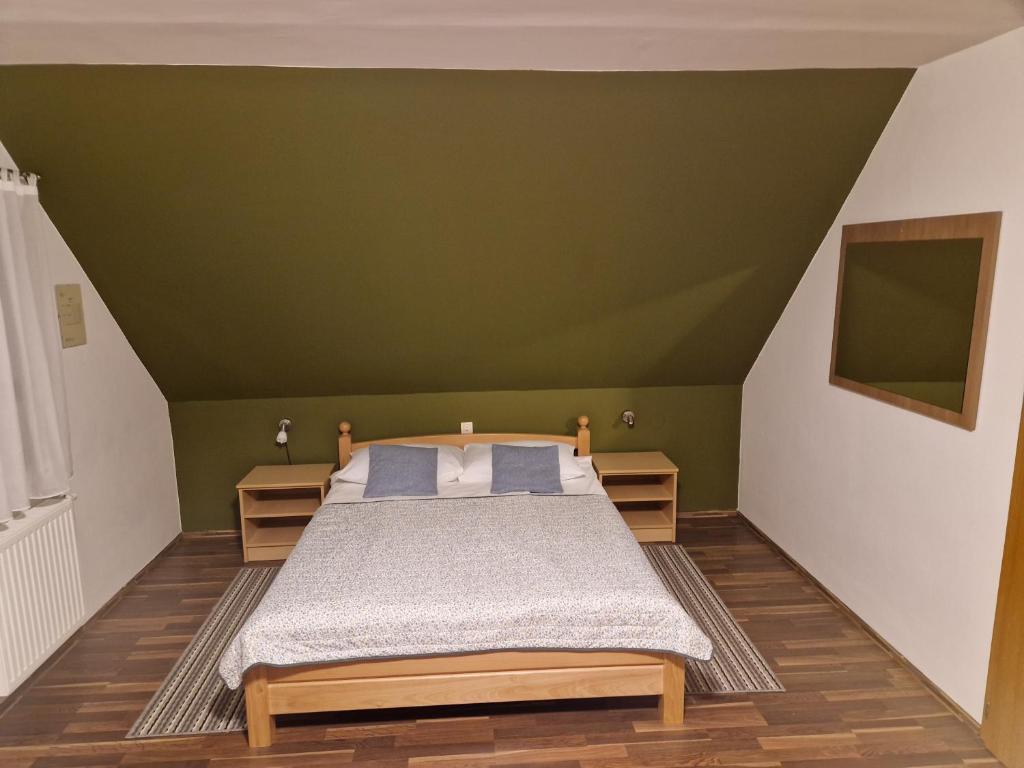 a bedroom with a bed and a green ceiling at Guest house Wolf II in Plitvička Jezera