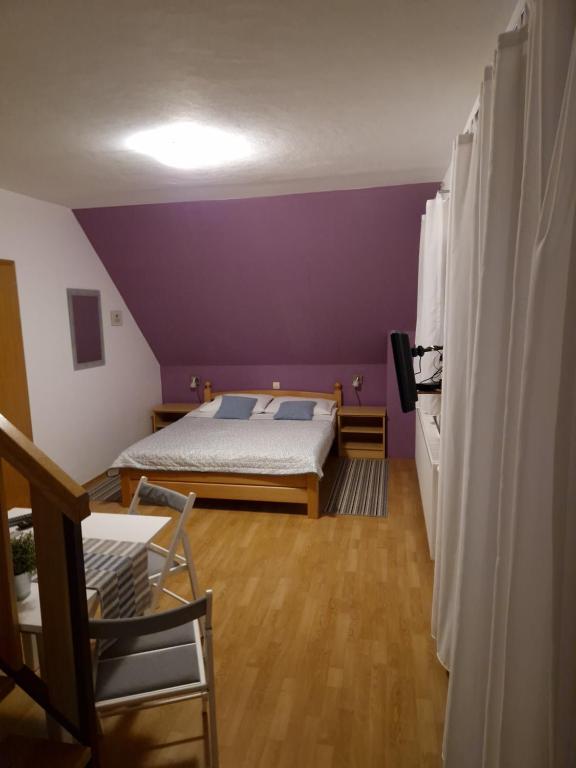 a bedroom with a bed and a purple wall at Guest house Wolf II in Plitvička Jezera
