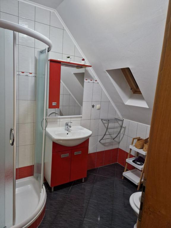 a bathroom with a sink and a red cabinet at Guest house Wolf II in Plitvička Jezera