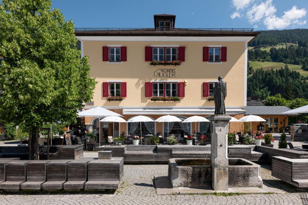 a large building with a fountain in front of it at Residence Kugler in San Candido