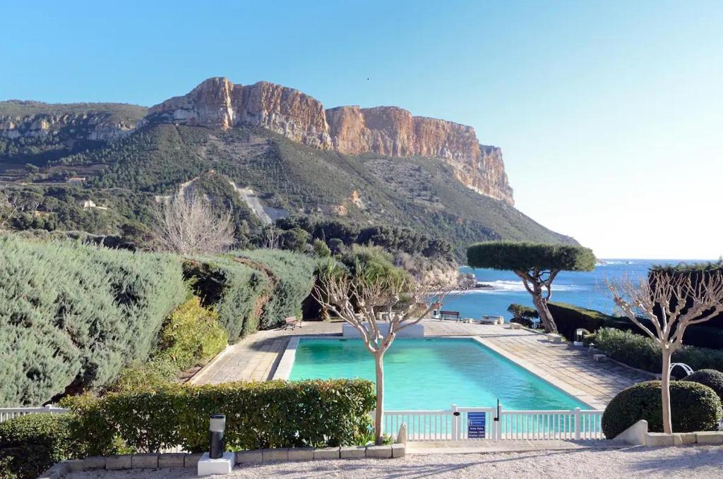 uma piscina com uma montanha ao fundo em Le Canaillou par Dodo-a-Cassis em Cassis