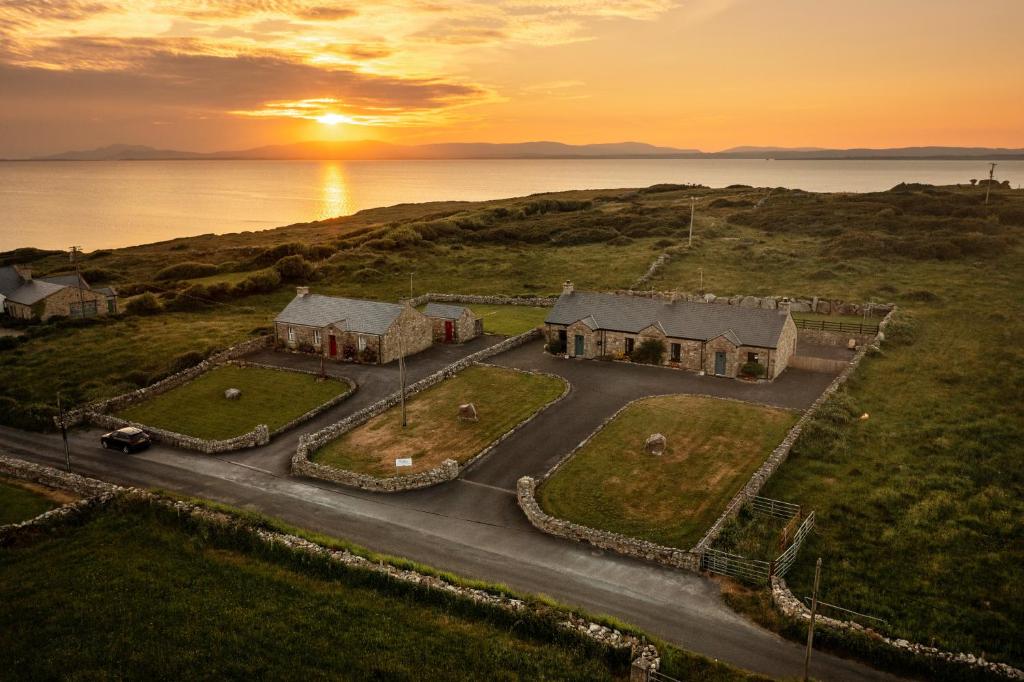 an aerial view of a house with the sunset in the background at Creevy Cottages in Rossnowlagh