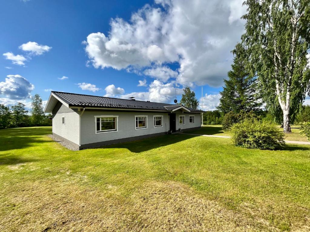 ein kleines weißes Haus auf einem großen Hof in der Unterkunft Villa Kupsala , LaatuLomat in Juva