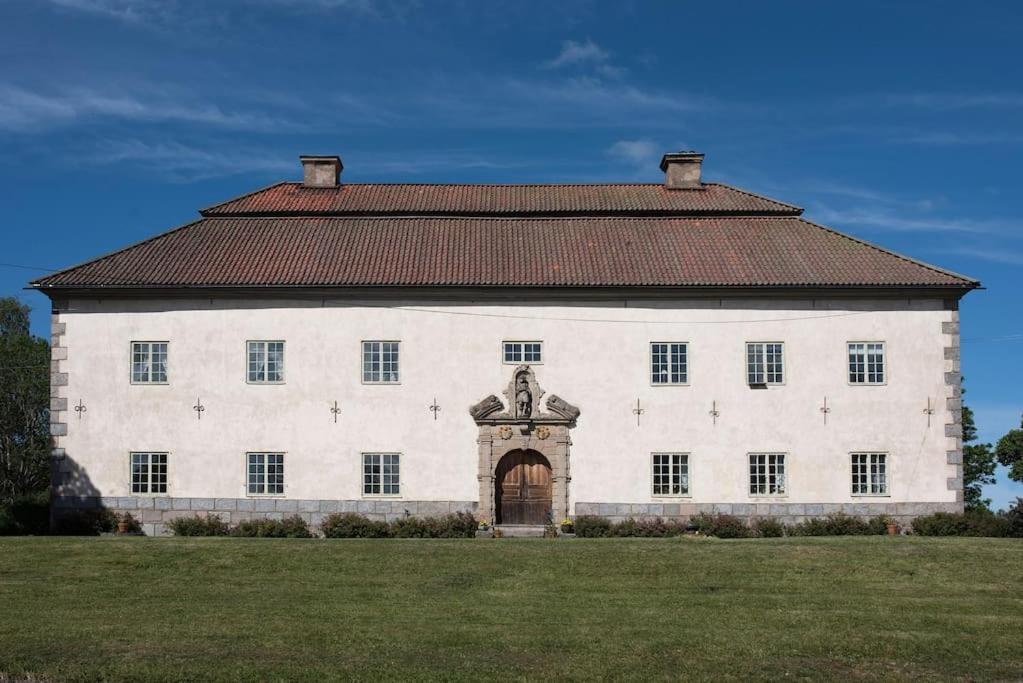 um grande edifício branco com uma estátua em frente em Lägenhet i slott från 1600-talet em Uppsala