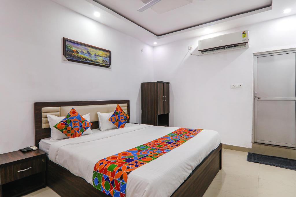 ein Schlafzimmer mit einem großen Bett mit bunten Kissen in der Unterkunft FabHotel A One Inn in Lucknow
