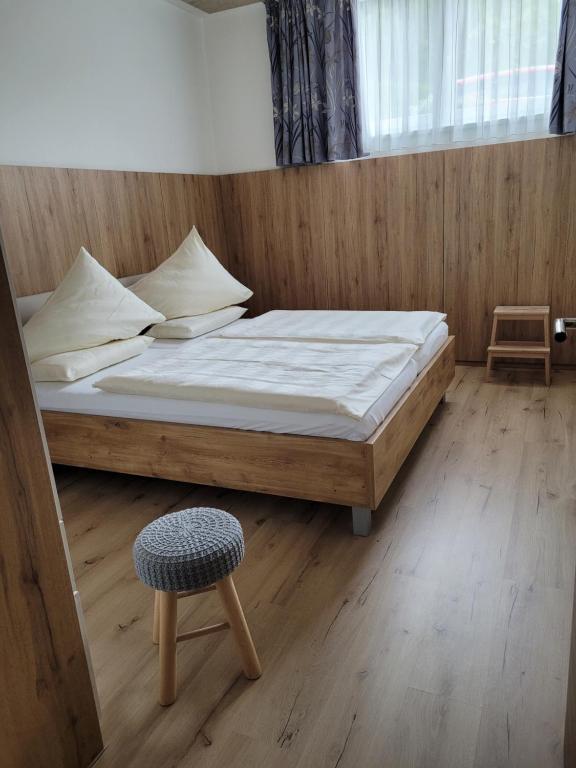 a bedroom with a large bed and a chair at Lucashof Millstättersee in Millstatt