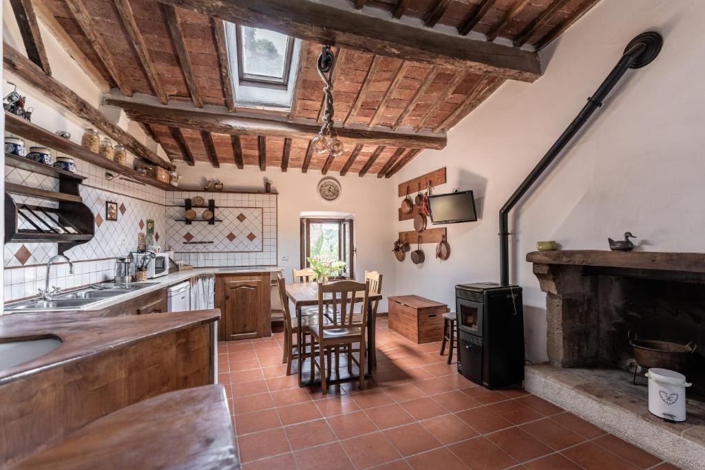 a kitchen with a fireplace and a table and chairs at Antica Porta di Sovana in Pitigliano