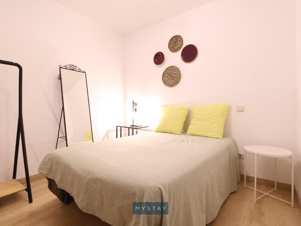 ein weißes Schlafzimmer mit einem Bett und einem Spiegel in der Unterkunft MyStay - Casa Esposende 