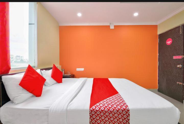um quarto com uma cama grande e almofadas vermelhas e brancas em MANAN PARADISE em Bangalore