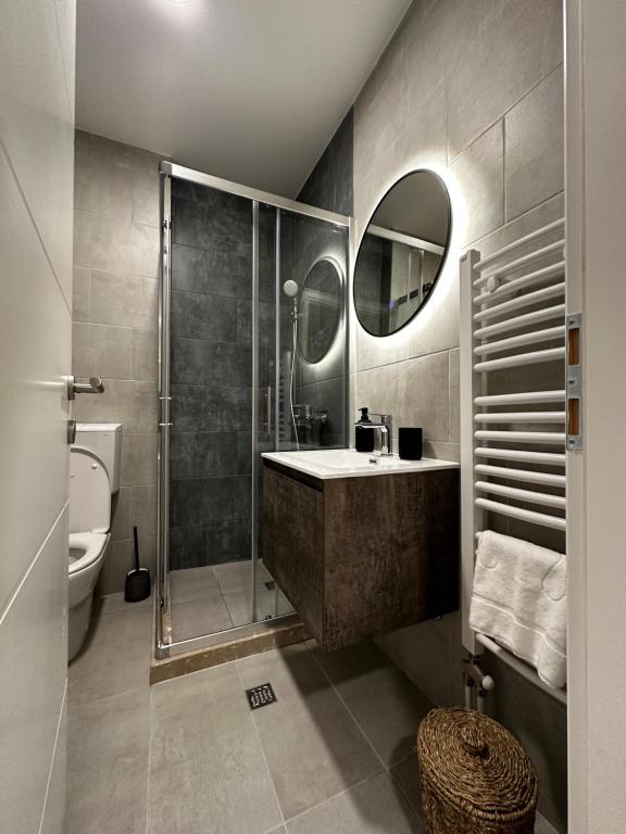 a bathroom with a shower and a sink and a toilet at Latea luxury apartment in Lukavica
