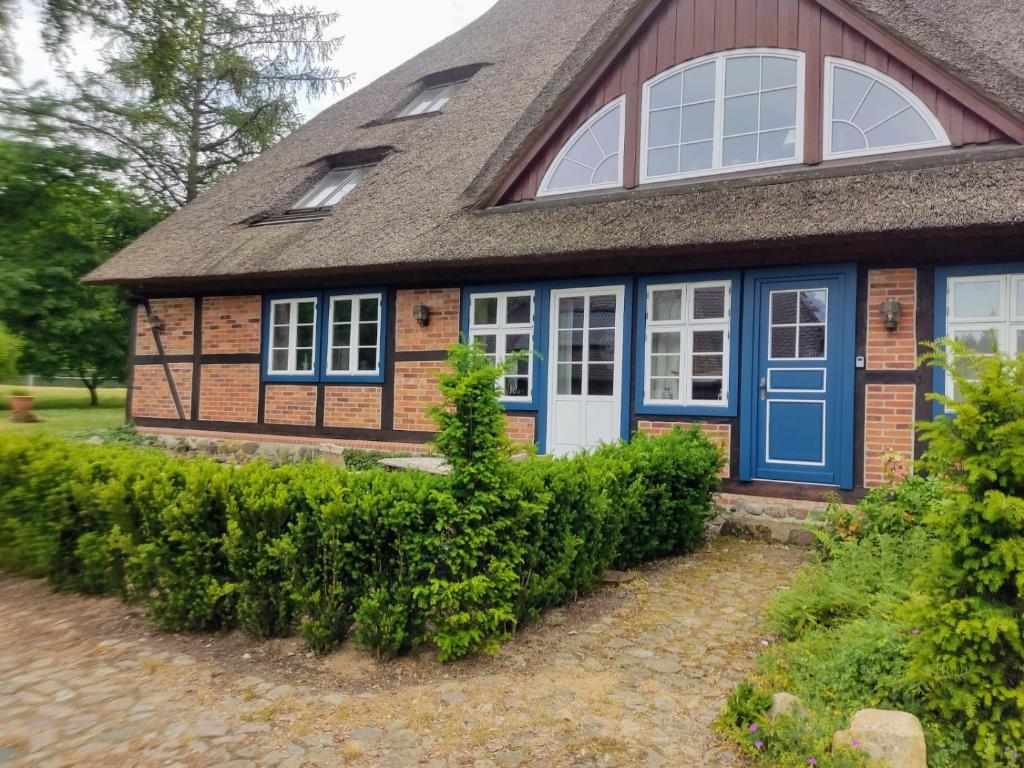 una casa con puertas azules y techo gris en Chalet Forsthof Everstorf - kleine Wohnung, en Grevesmühlen