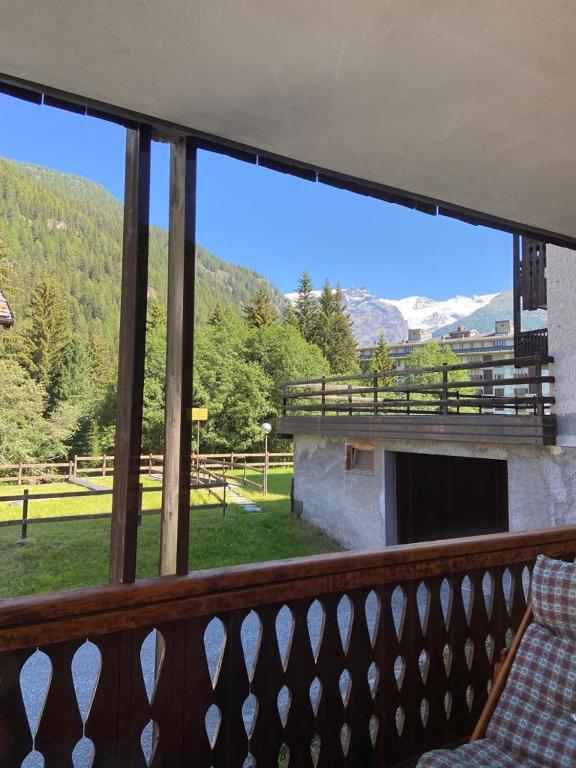 a balcony with a view of a field and mountains at Il Ricordo appartamento in Champoluc