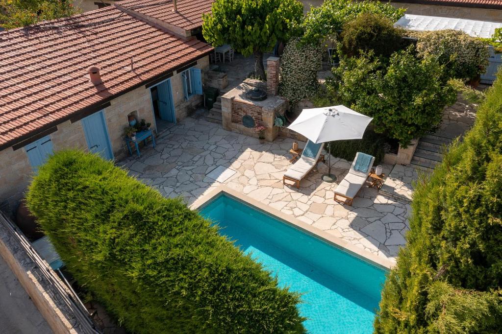 - une vue sur la piscine avec un parasol dans l'établissement Villa Avgoustis, à Pachna