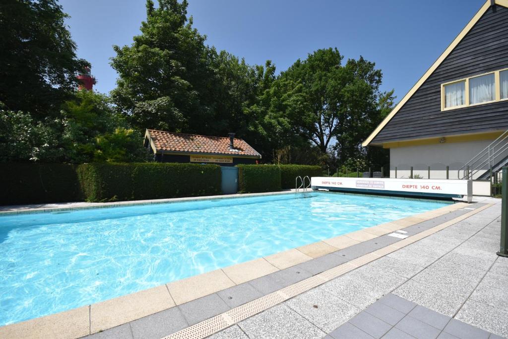 - une piscine en face d'une maison dans l'établissement Hotel De Torenhoeve, à Burgh-Haamstede