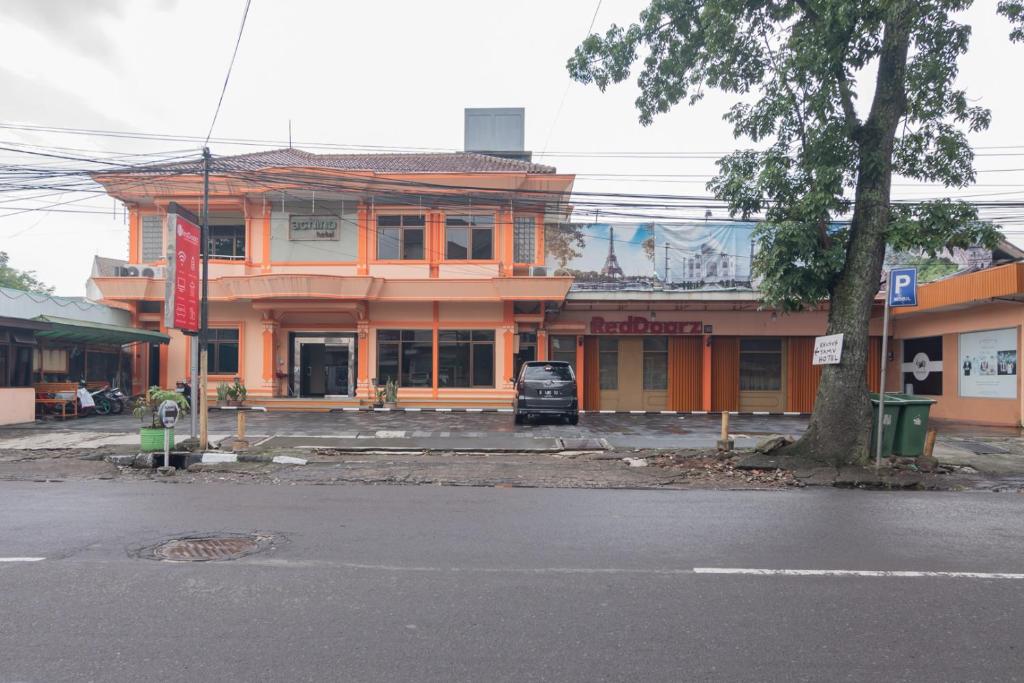 un edificio naranja al lado de una calle en RedDoorz @ Achino Hotel Bandung, en Bandung