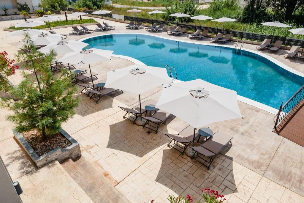 una vista sul soffitto di una piscina con ombrelloni e sedie di Hotel Olea a Ulcinj