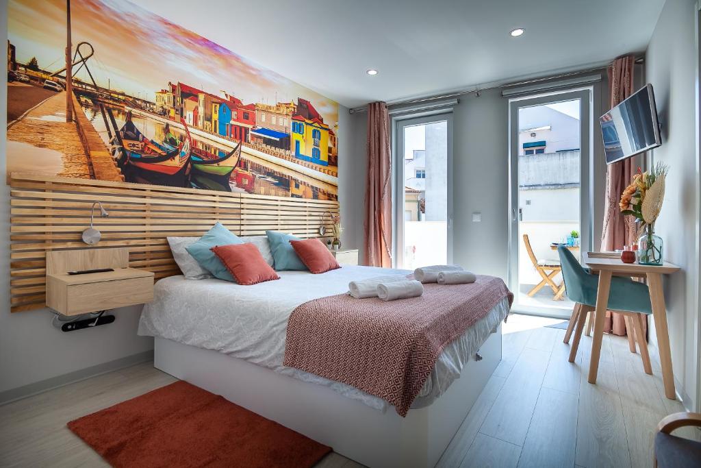 1 dormitorio con 1 cama con una pintura en la pared en Casita São Gonçalinho by Home Sweet Home Aveiro en Aveiro
