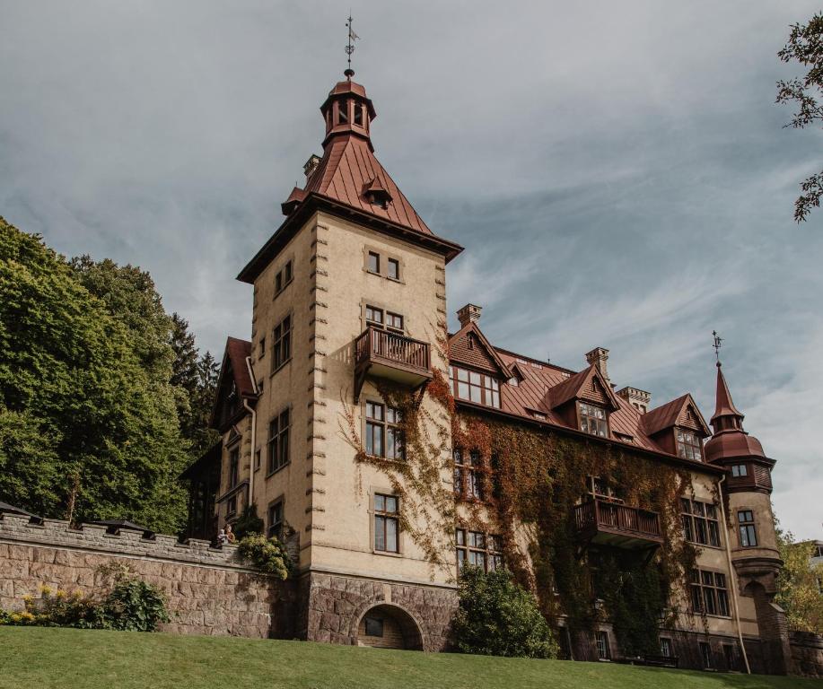 um edifício antigo com uma torre em cima em Hotel Slottsvillan em Huskvarna