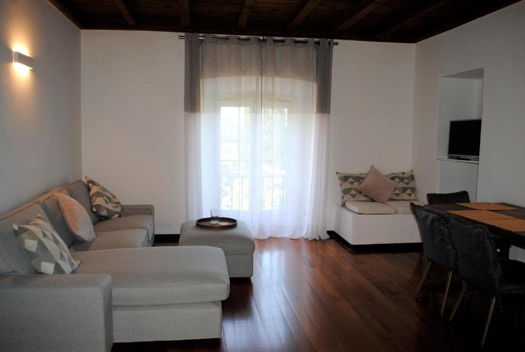 sala de estar con sofá y ventana en Vista Lago Apartment, en Bellagio