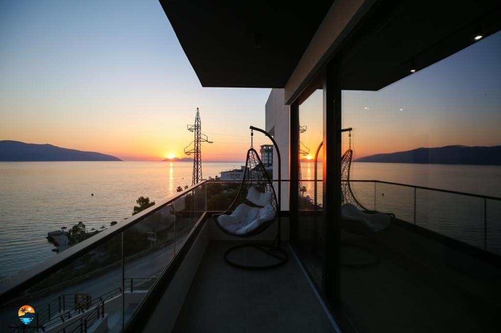 a boat in the water with the sunset in the background at Sunny Hill Residence in Vlorë