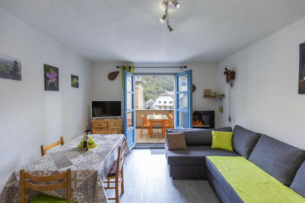 ein Wohnzimmer mit Couch und Tisch in der Unterkunft Appartement Terrasse Vue Montagne in Campan