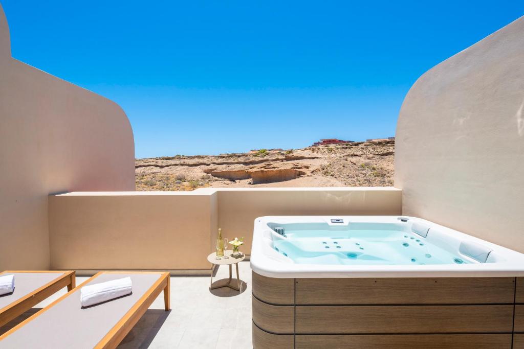 a hot tub in a room with a view of the desert at MEDANO4YOU Eternal Spring Holiday Home in El Médano