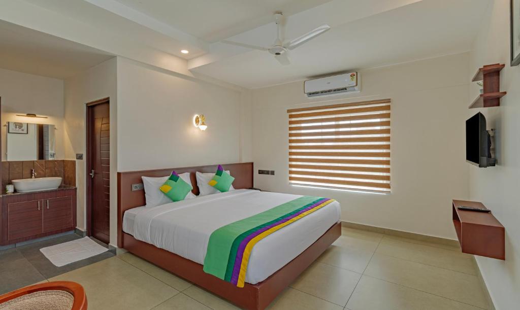 um quarto com uma cama, uma banheira e uma televisão em Treebo Trend Amigos Residency em Cochin