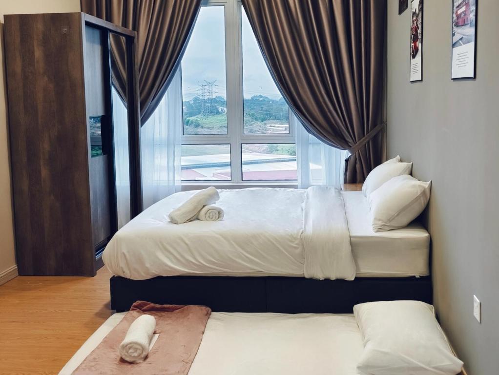 two beds in a room with a large window at Valley Suites by WyattHomes in Kuantan