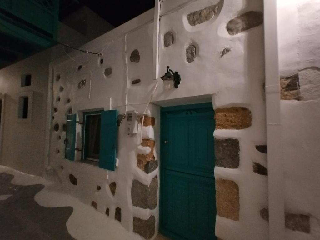 a wall with a green door in a building at Φως (Fos) in Astypalaia