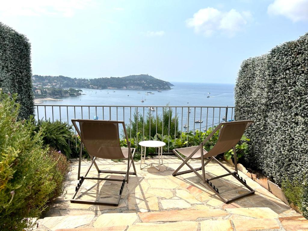 d'une terrasse avec 2 chaises et une table et vue sur l'océan. dans l'établissement Studio Leopolda, à Villefranche-sur-Mer