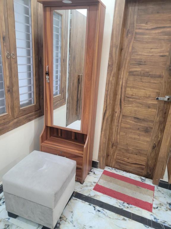 a room with a door and a stool and a mirror at Gupta Residence. in Dhanbād