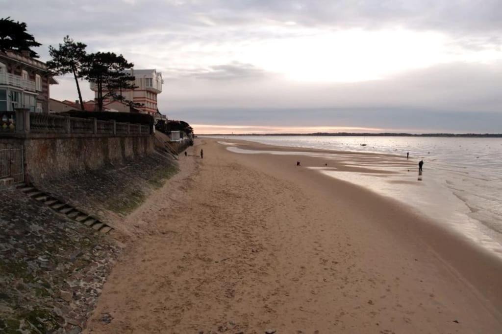 une plage avec des gens qui marchent sur le sable et l'eau dans l'établissement MAISON DE VILLE PRES DE LA PLAGE, à Arcachon