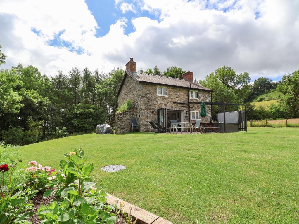 an old stone house on a grassy yard at Cae Iocyn in Wrexham